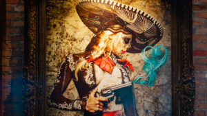 Framed painting of mariachi woman with sugar skull face paint