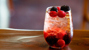 Ice cold cocktail with black berries and raspberries
